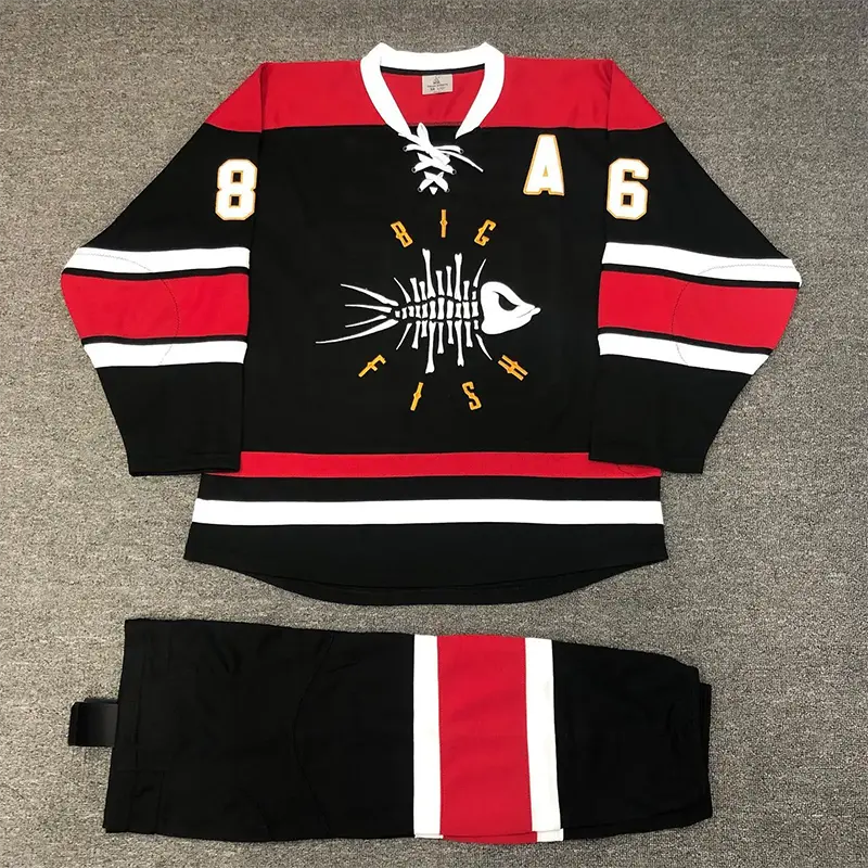 Black, red, and white hockey jersey and pants set laid flat